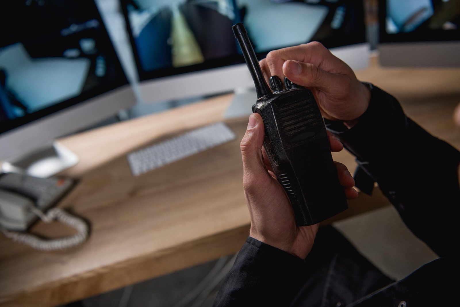 Security officer using a two-way radio at a security desk