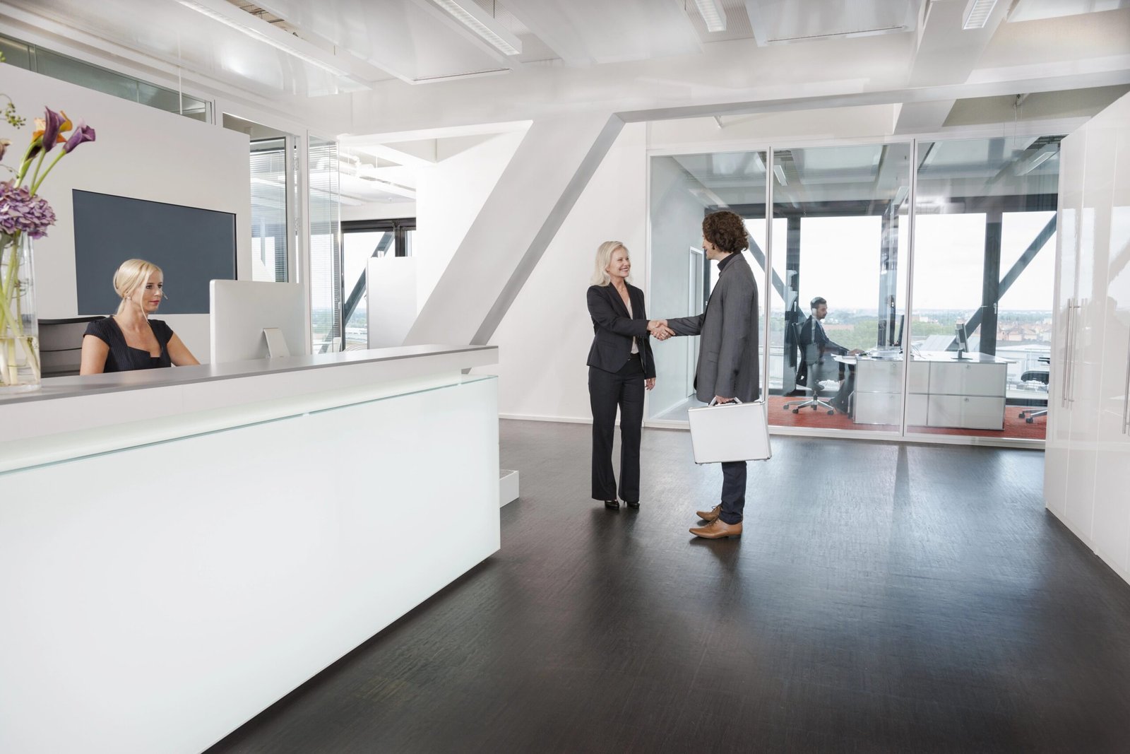 Concierge welcoming a visitor at a reception desk